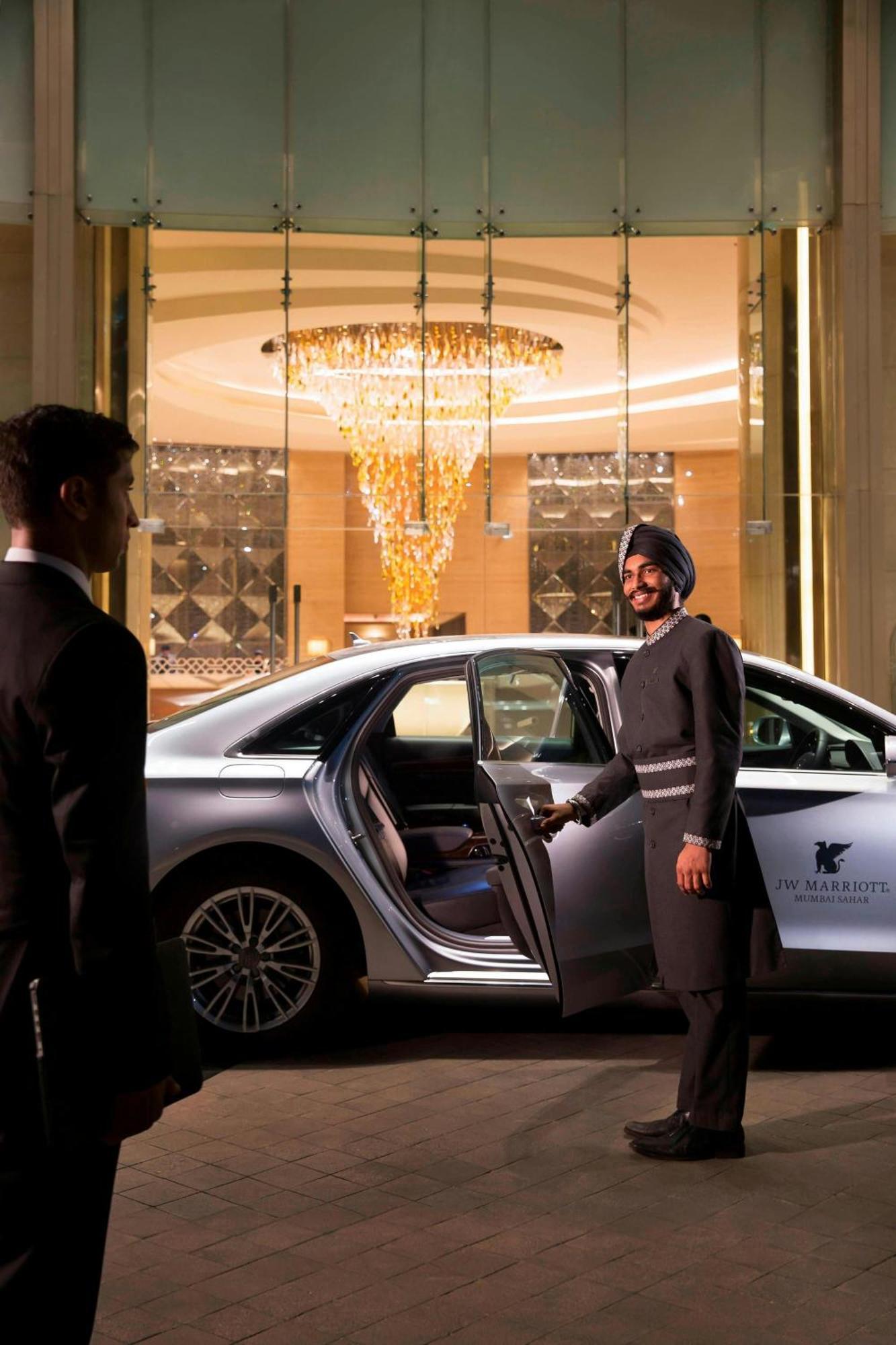 Hotel Jw Marriott Mumbai Sahar Airport Exteriér fotografie A chauffeur opening a car door at JW Marriott, Dubai